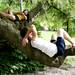 Troy resident Jing Gung and her friend Roman Novitski relax in a tree overlooking The Peony Garden on Tuesday, June 4. Daniel Brenner I AnnArbor.com